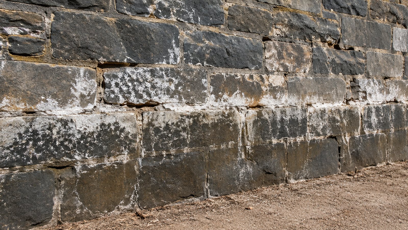 Bluestone wall base with efflorescence and fretting mortar